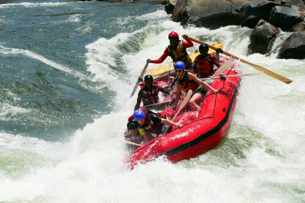 2 men riding red kayak on sea during daytime
